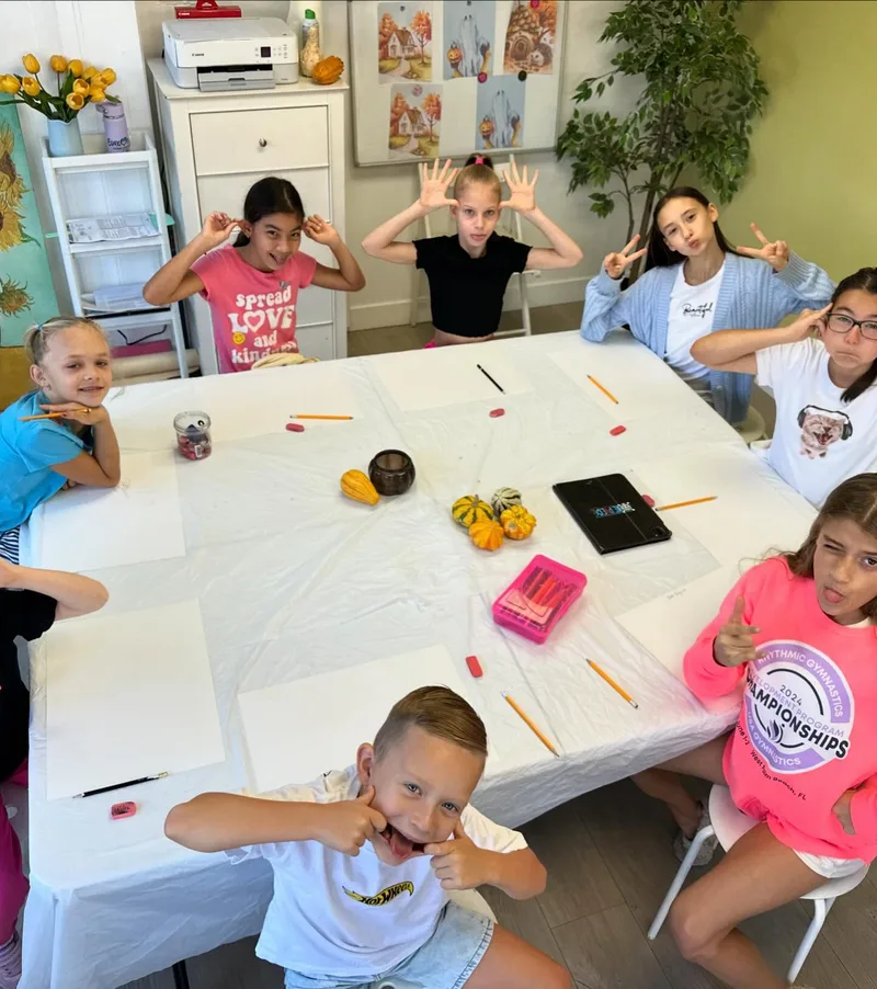 Kids at a group art class, sketching a fall still life